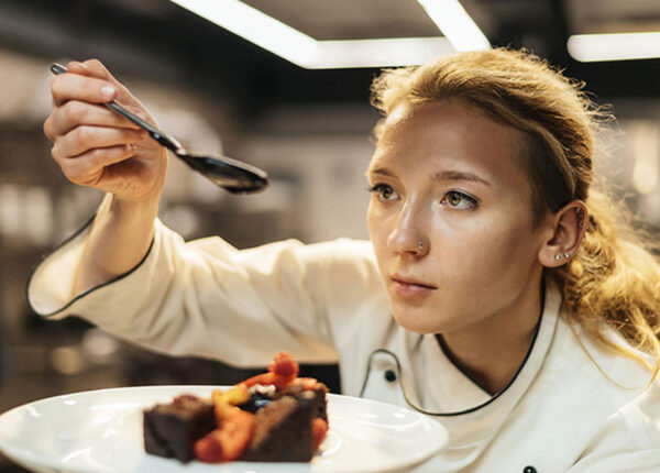 Imagem mostra uma Chef de cozinha preparando um prato para um press release de uma assessoria de imprensa especializada em gastronomia.