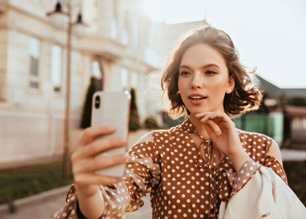 Imagem mostra uma mulher que trabalha como social influencer fazendo uma selfie